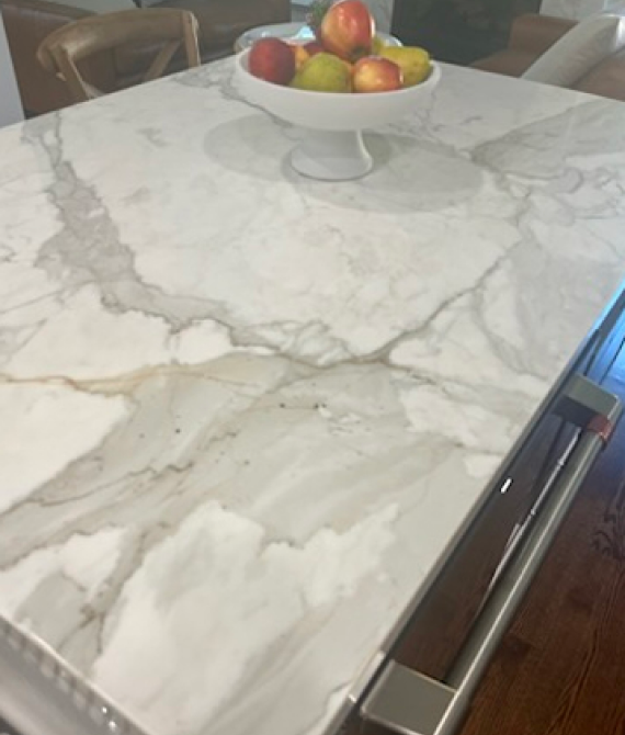 Marble countertop with fruit bowl centerpiece.