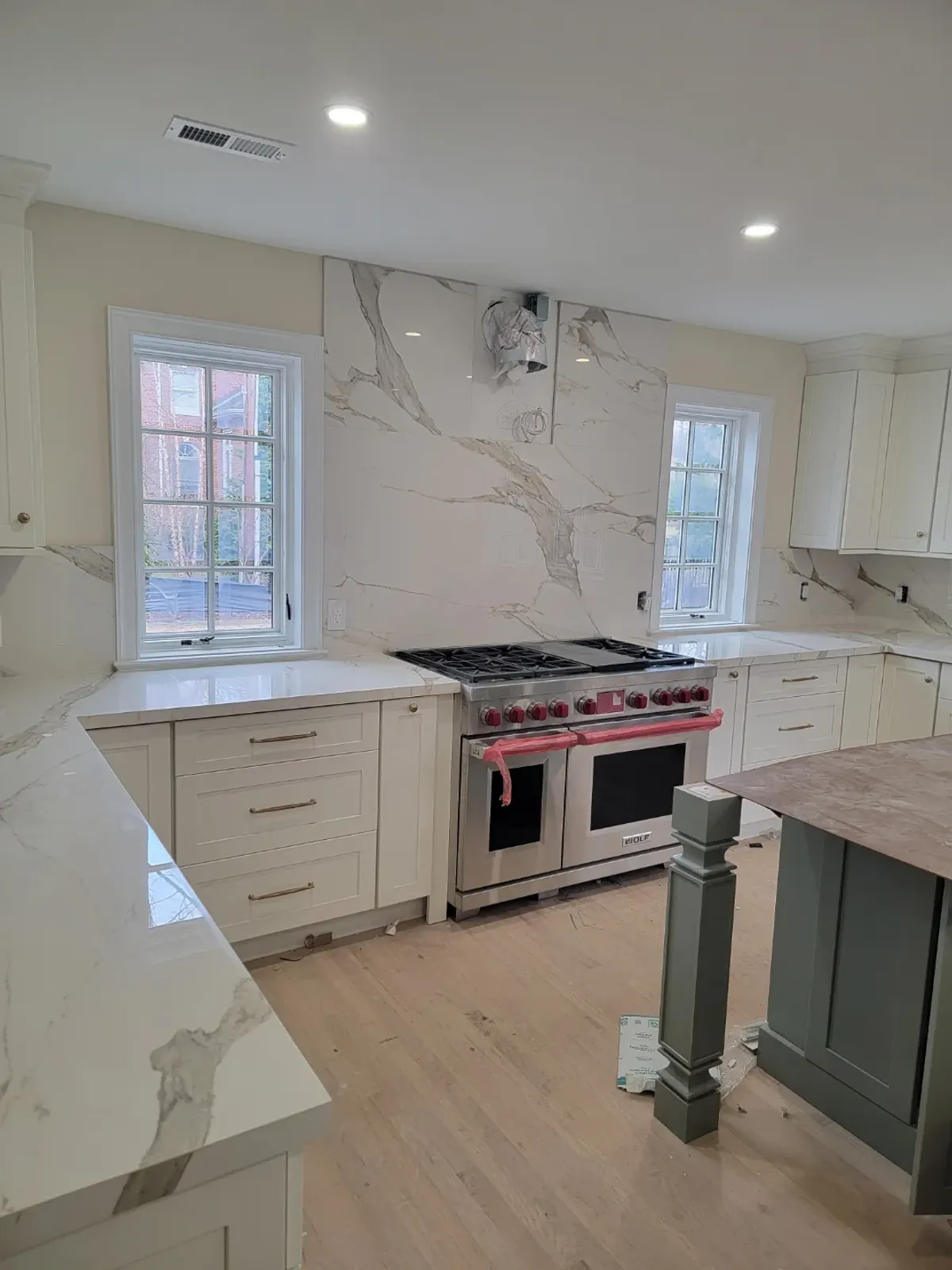 Modern kitchen with marble countertops and stove.
