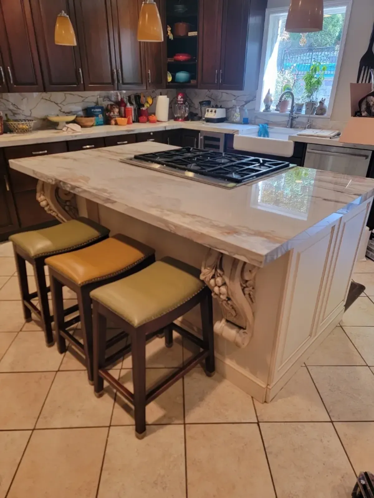 Kitchen island with stools and marble countertop.