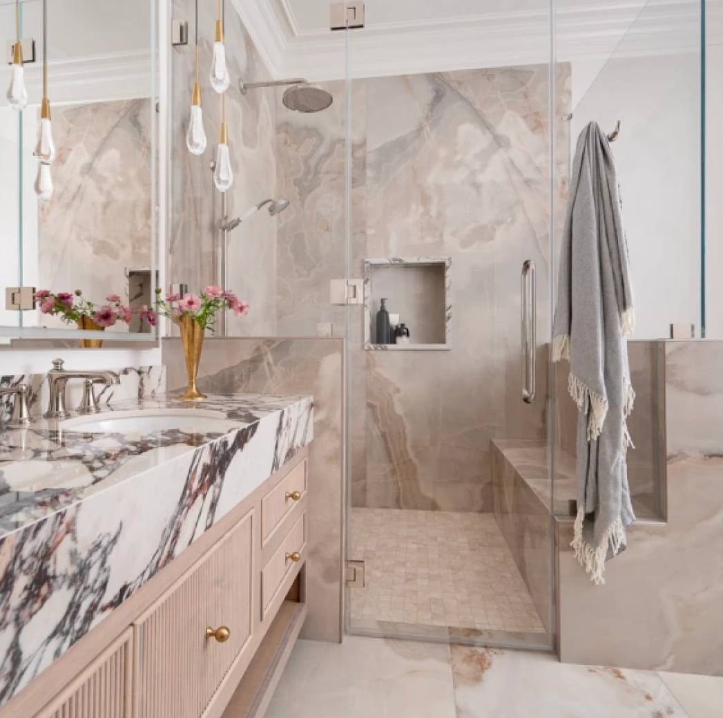 Luxurious marble bathroom with elegant fixtures and soft lighting.