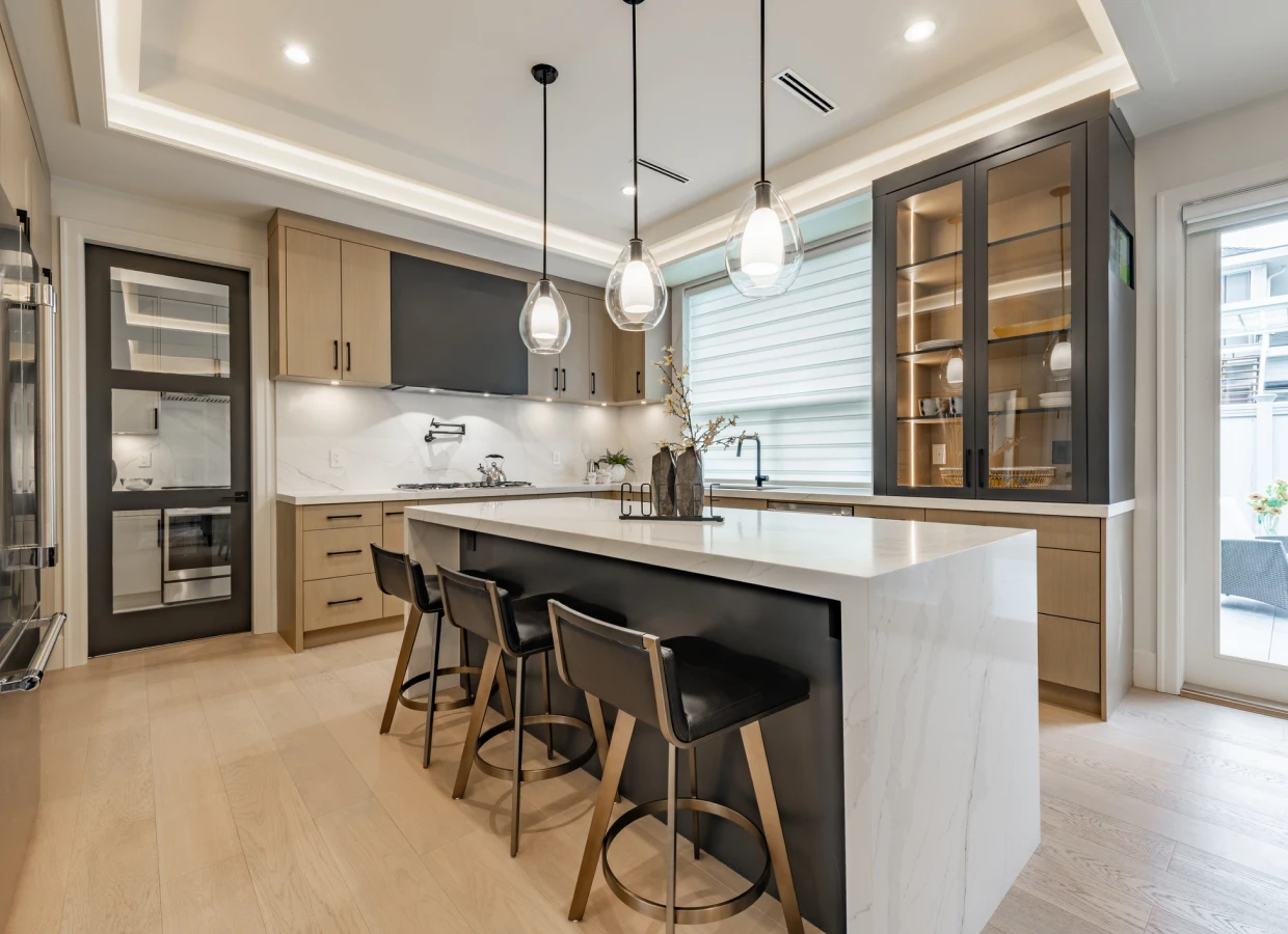 Modern kitchen with island and pendant lights.