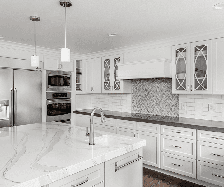 Modern white kitchen with marble countertops.