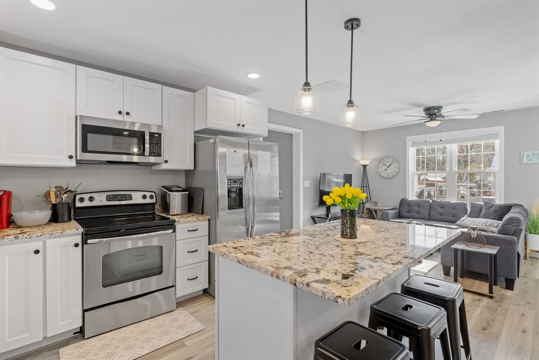 Modern kitchen with granite island and stainless steel appliances.