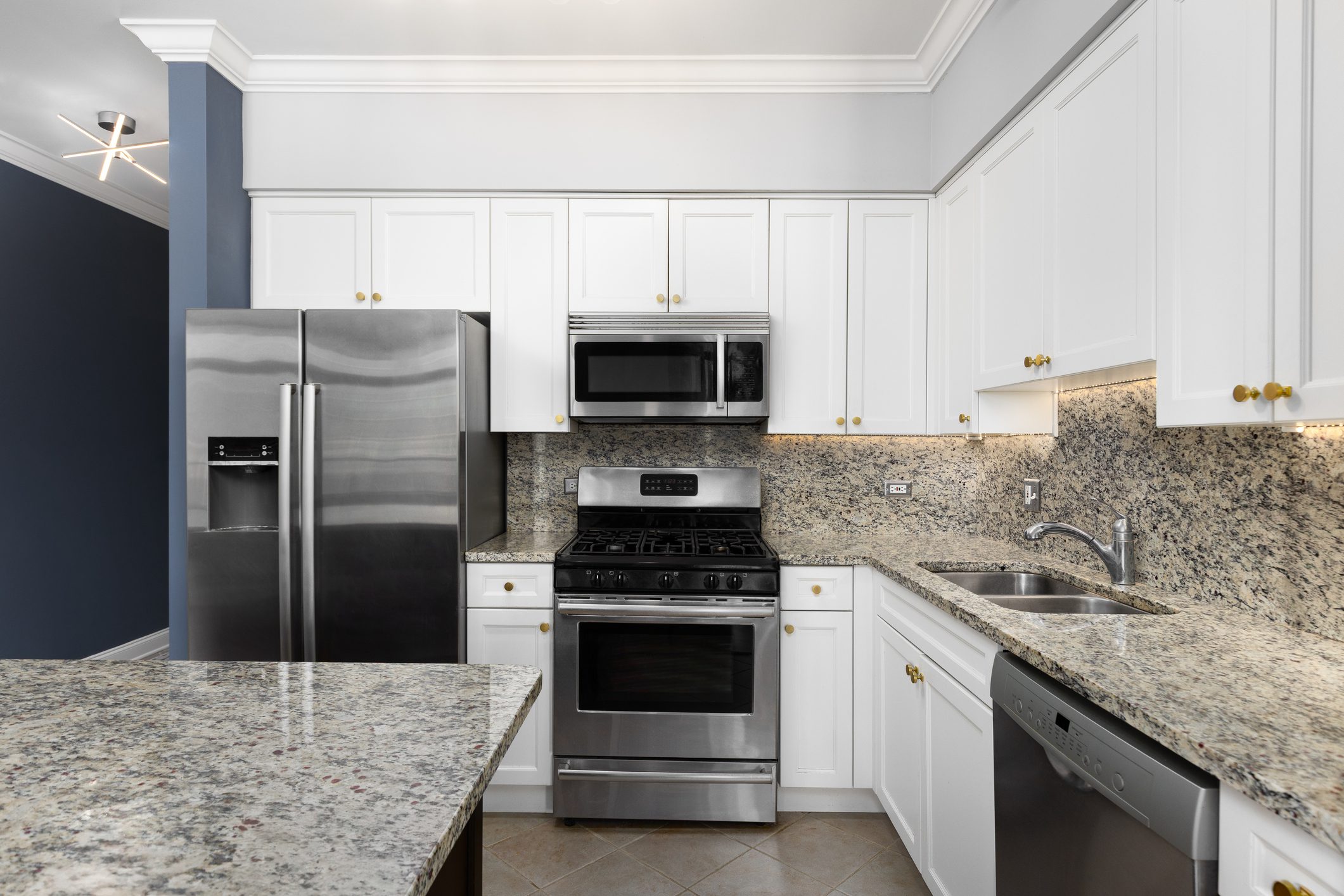 Modern kitchen with granite countertops and stainless steel appliances.